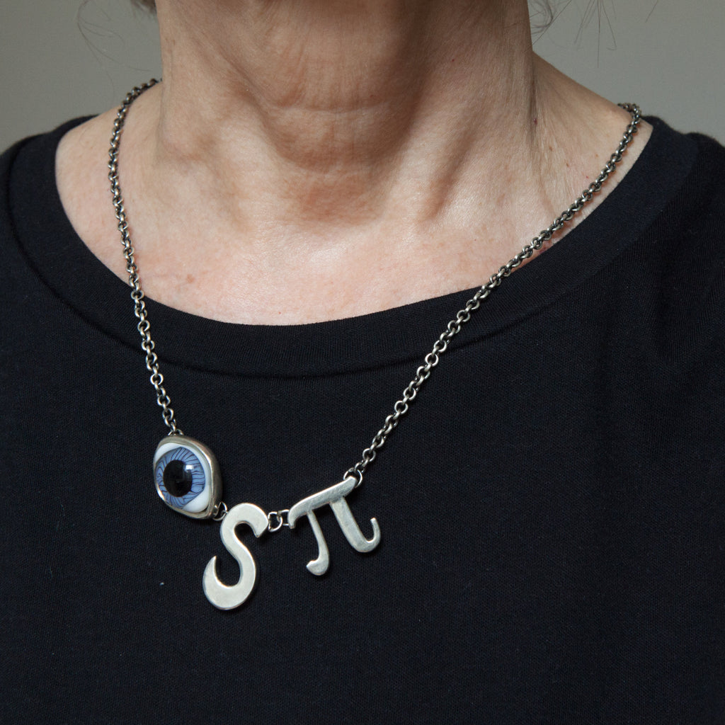 I spy sterling silver necklace with a glass doll's eye is shown being worn.