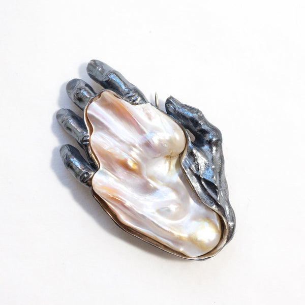 A baroque pearl as the back of a blackened silver left hand brooch. Front