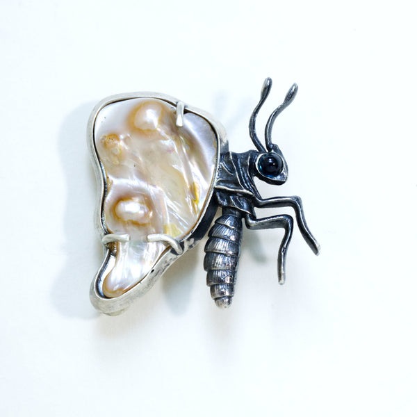 Baroque pearl winged butterfly with a sapphire eye, sterling silver partly blackened. Front
