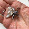 Baroque pearl winged butterfly with a sapphire eye, sterling silver partly blackened. in a hand