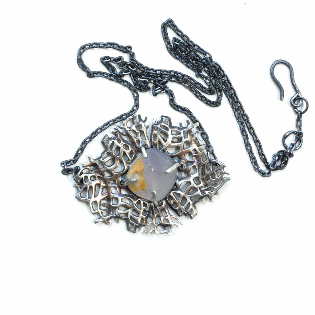 blue chalcedony shell in a sterling silver sea fan lightly tinted with a liver of sulfur patina. Front with chain and clasp