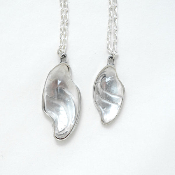 carved quartz silver necklaces with design on the back. front view
