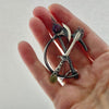 cutting through sterling silver brooch with a star ruby and peridot see on a hand to show its size