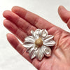Spring time dahlia, silver with a 10 gold disc floret, topaz dewdrops brooch. in a hand