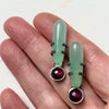 chrysoprase and rhodolite garnet in an exclamation point arrangement. With shoelace setting. in a hand