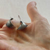 fin sterling silver earrings shown in the palm of a hand for size comparison