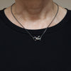 flying bird silver necklace with a sapphire eye is shown being worn.