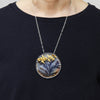 Round dendritic agate bush with golden swallows flying by. Brooch pendant. shown worn.