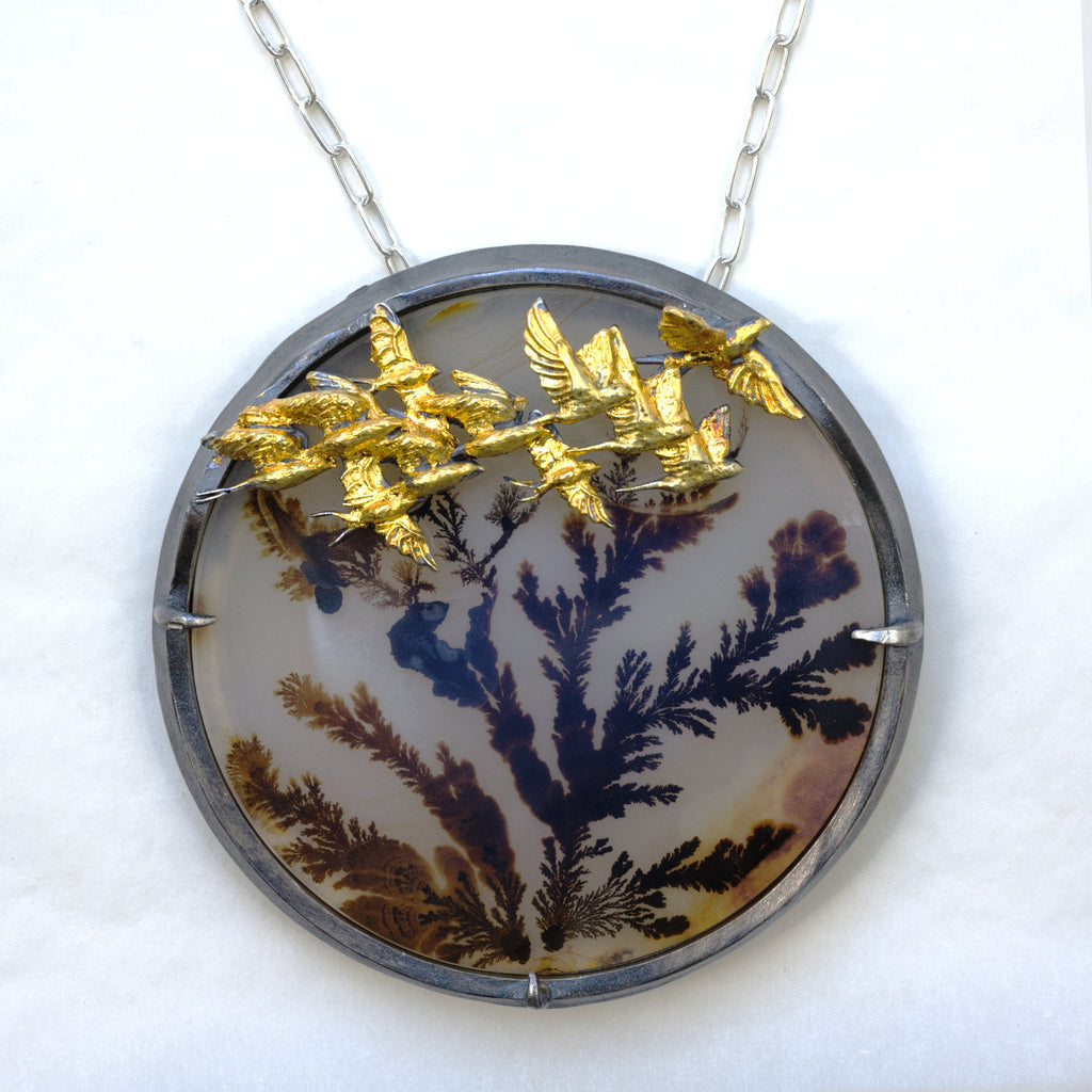 Round dendritic agate bush with golden swallows flying by. Brooch pendant. Front with chain
