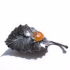 spessartite garnet ladybug on a sterling silver leaf blackened with liver of sulfur, and a topaz dewdrop. SIde