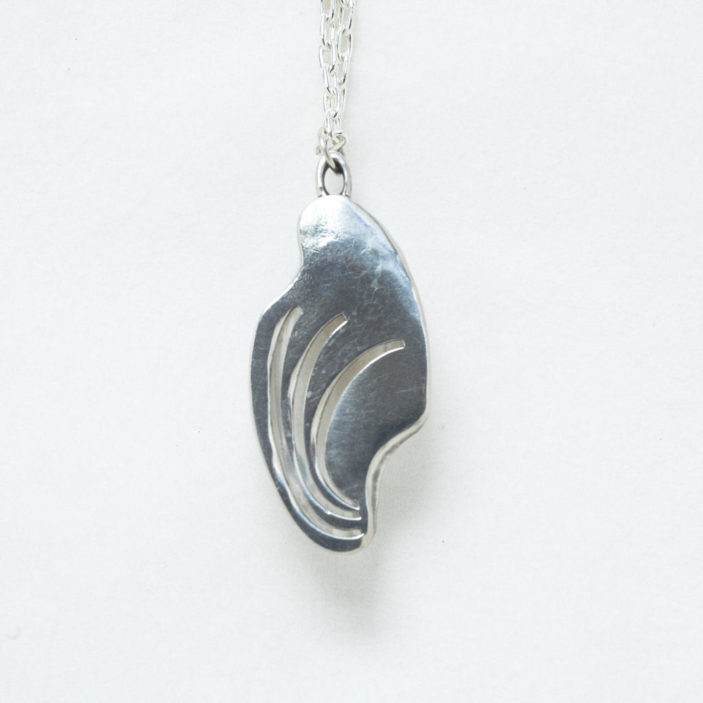large carved quartz silver necklace with design on the back. back view