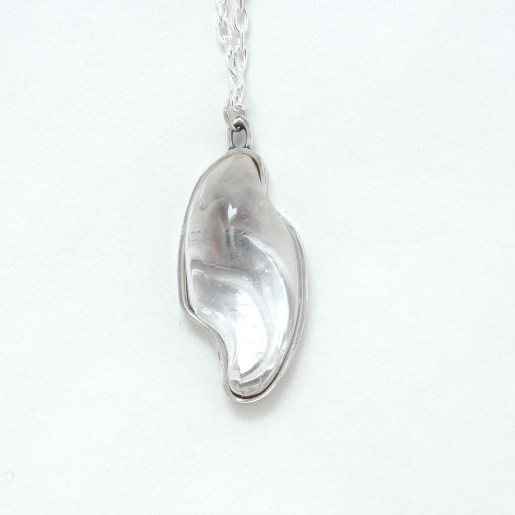 large carved quartz silver necklace with design on the back. front view