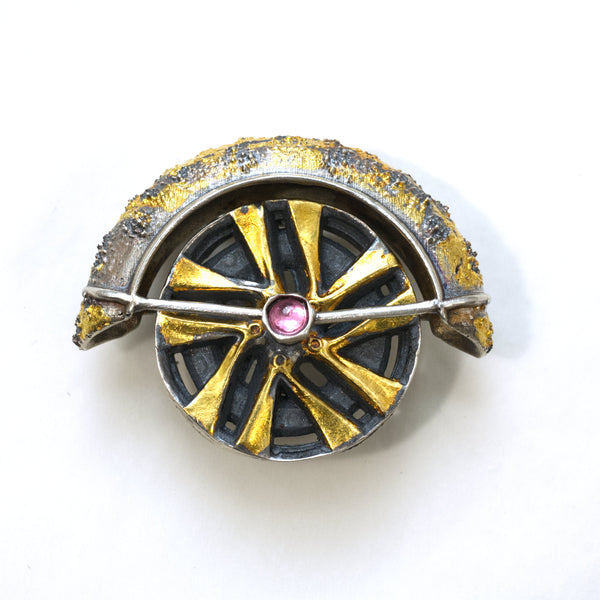 Lux fender brooch pendant with a pink spinel , blackened ssilver. 24k gold fused using keum boo process. The hubcap spins. Front.