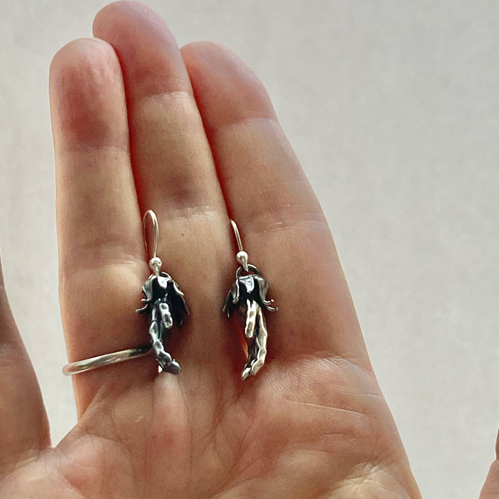 pierrot hands sterling silver earrings shown in a hand for size comparison