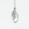 small carved quartz silver necklace with design on the back. front view