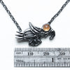 soaring bird, blackened silver with a spessartite garnet eye-measure