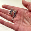 starlight tanzanite silver earrings. in a hand