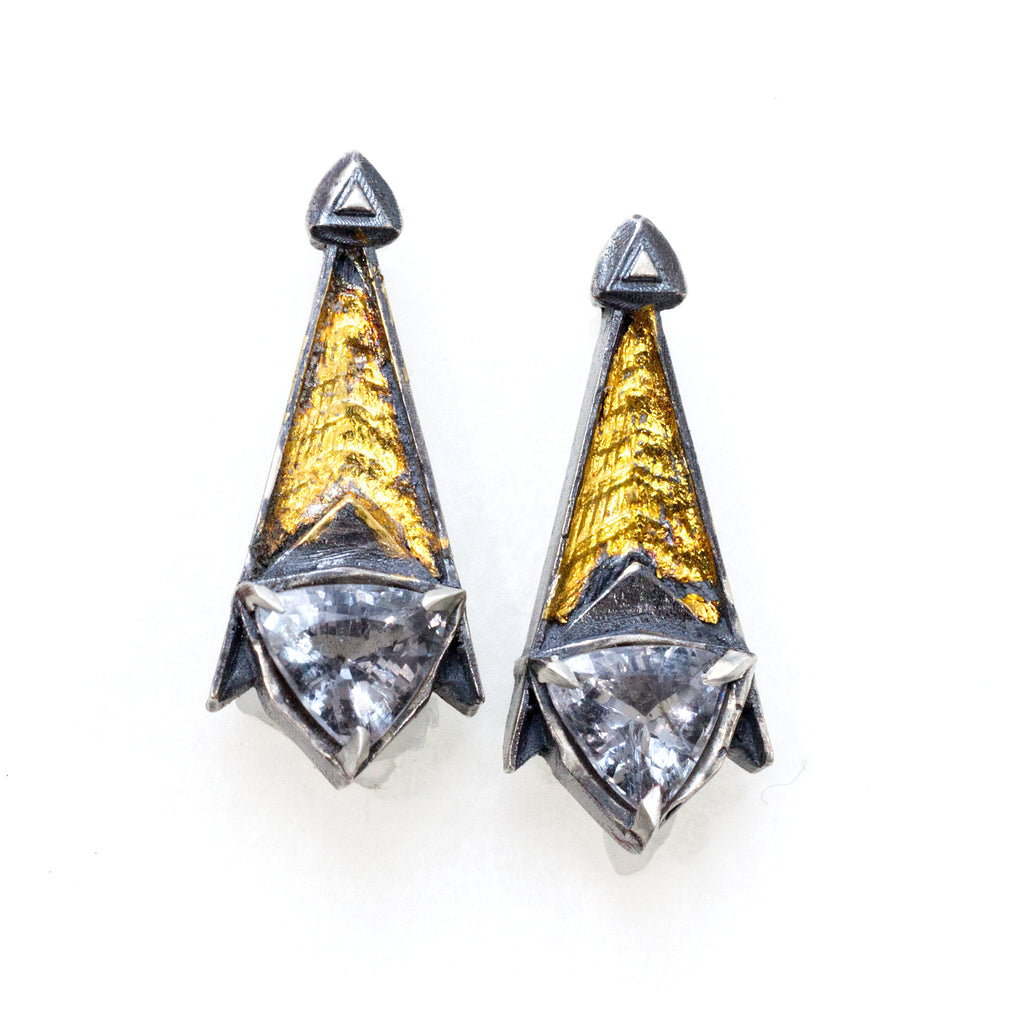 Grey spinel tri post back earrings. BLackened siver 24k gold foil fused to the silver. triangular grey spinels.Front