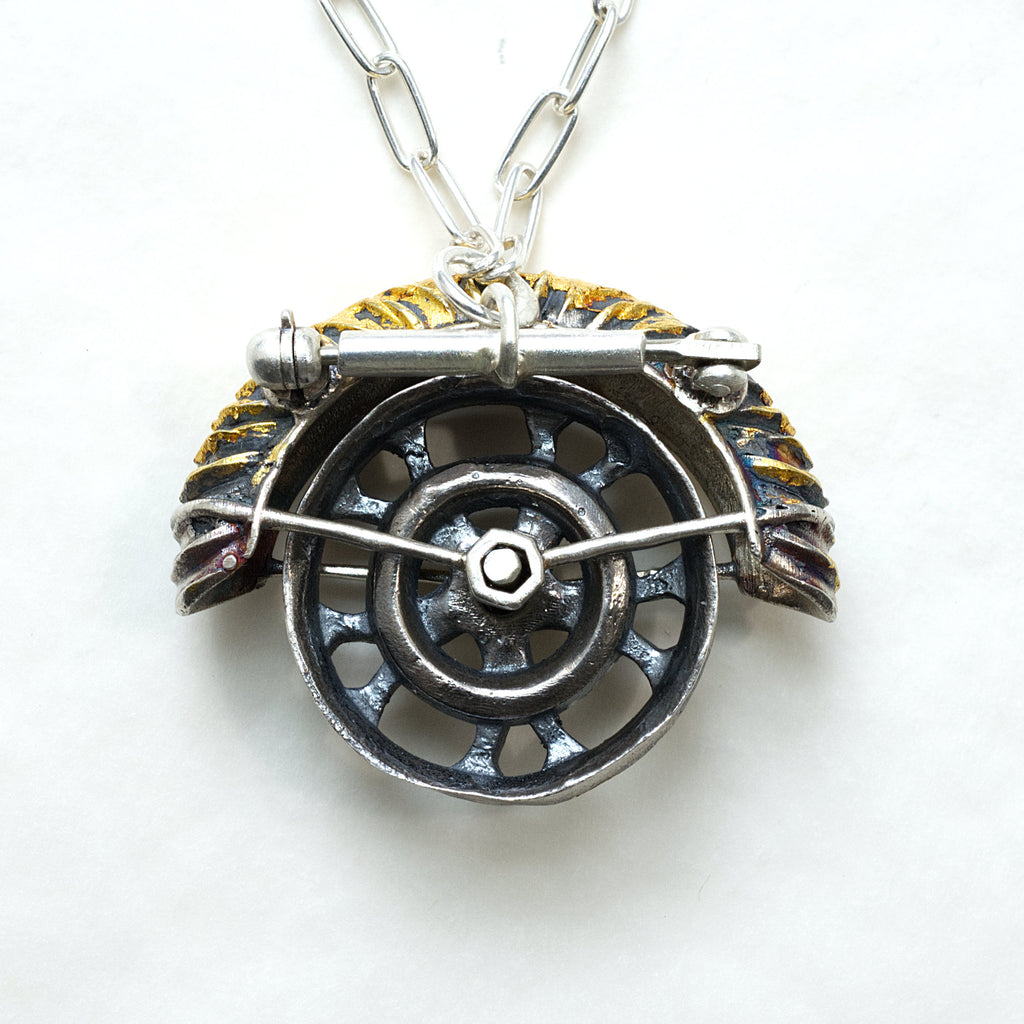 yaya fender brooch pendant. Blackened sterling silver, 24k gold foil applied using keum boo. The hubcap spins. back with chain